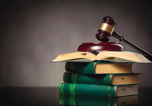 Stack of lawbooks with a gavel on top illustrating the lawyers will work for their client.