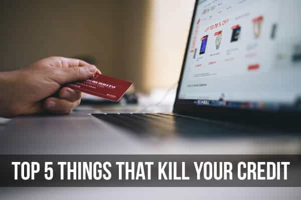 Person holding a credit card in front of a computer screen