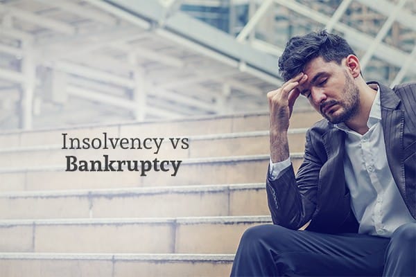 A man sits on the stairs looking stressed and defeated beside the words "Insolvency vs Bankruptcy"